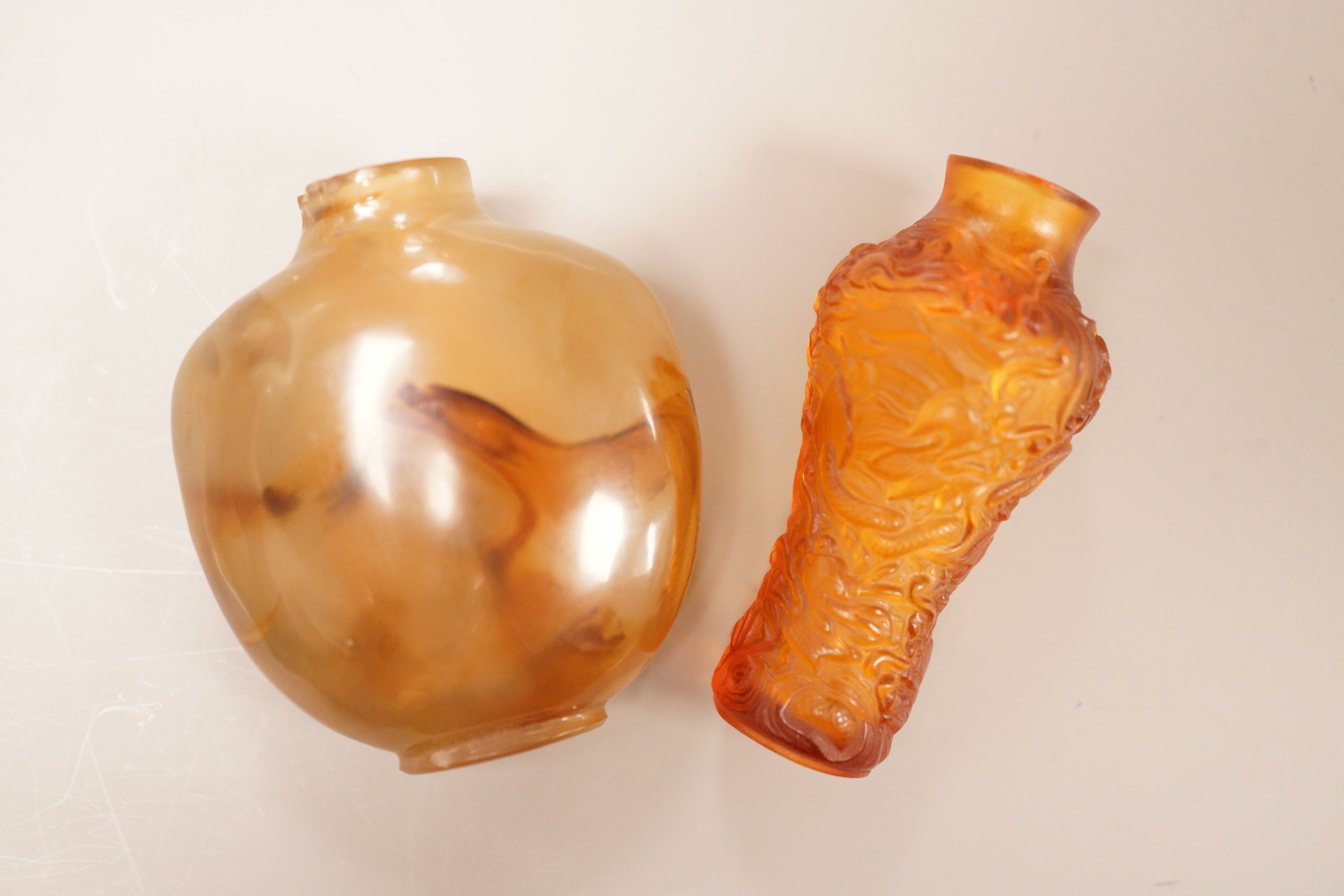 A Chinese agate snuff bottle and an amber glass snuff bottle